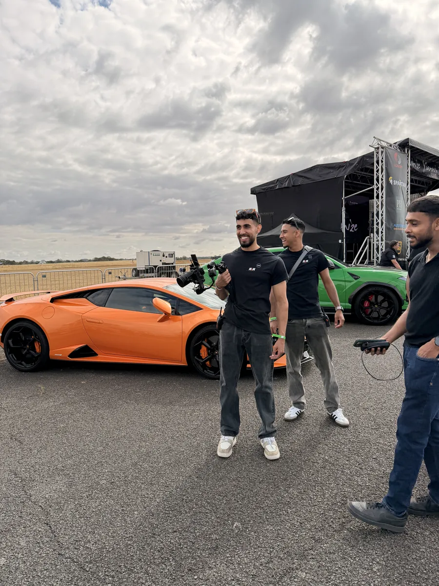 An orange supercar on a show stage